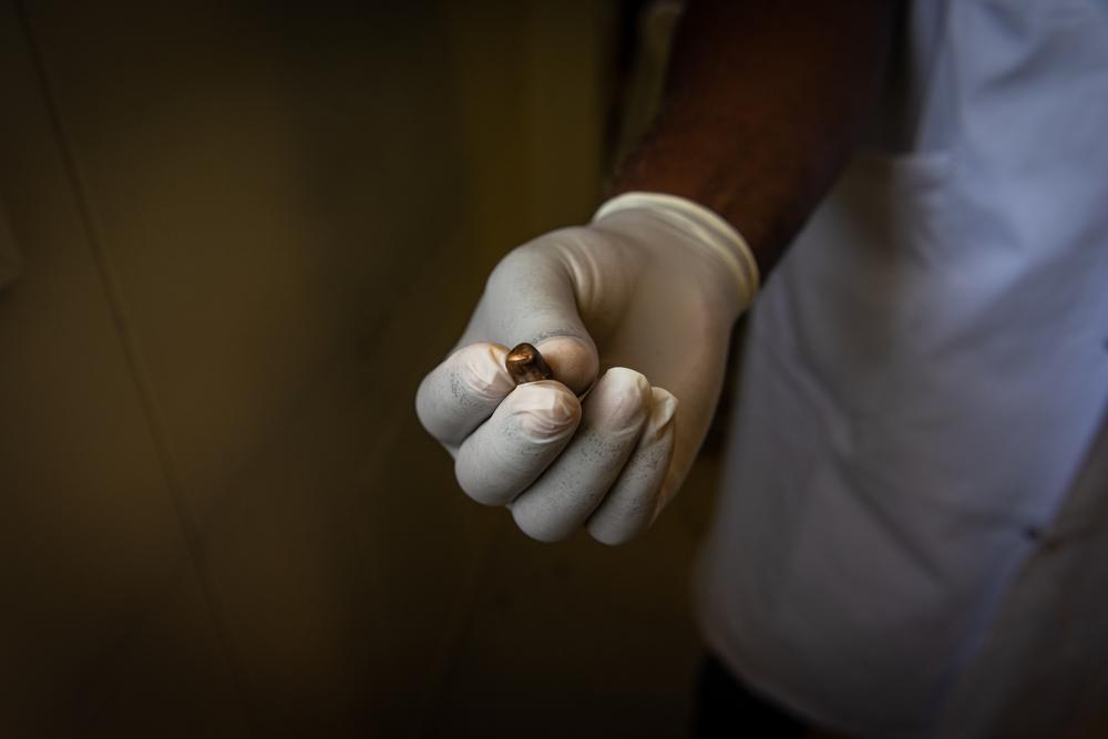  Un médecin de MSF montre une balle extraite du corps d'un civil blessé dans un quartier de Port-au-Prince. 